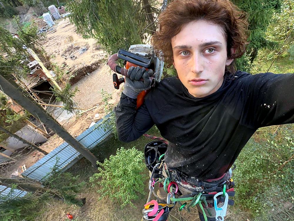 Савелий, основатель Moscow Tree Service, на высоте с бензопилой
